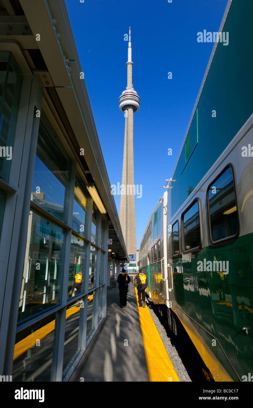 GO train at Union Station Toronto with CN Tower and work crew in the morning with blue sky Stock Photo