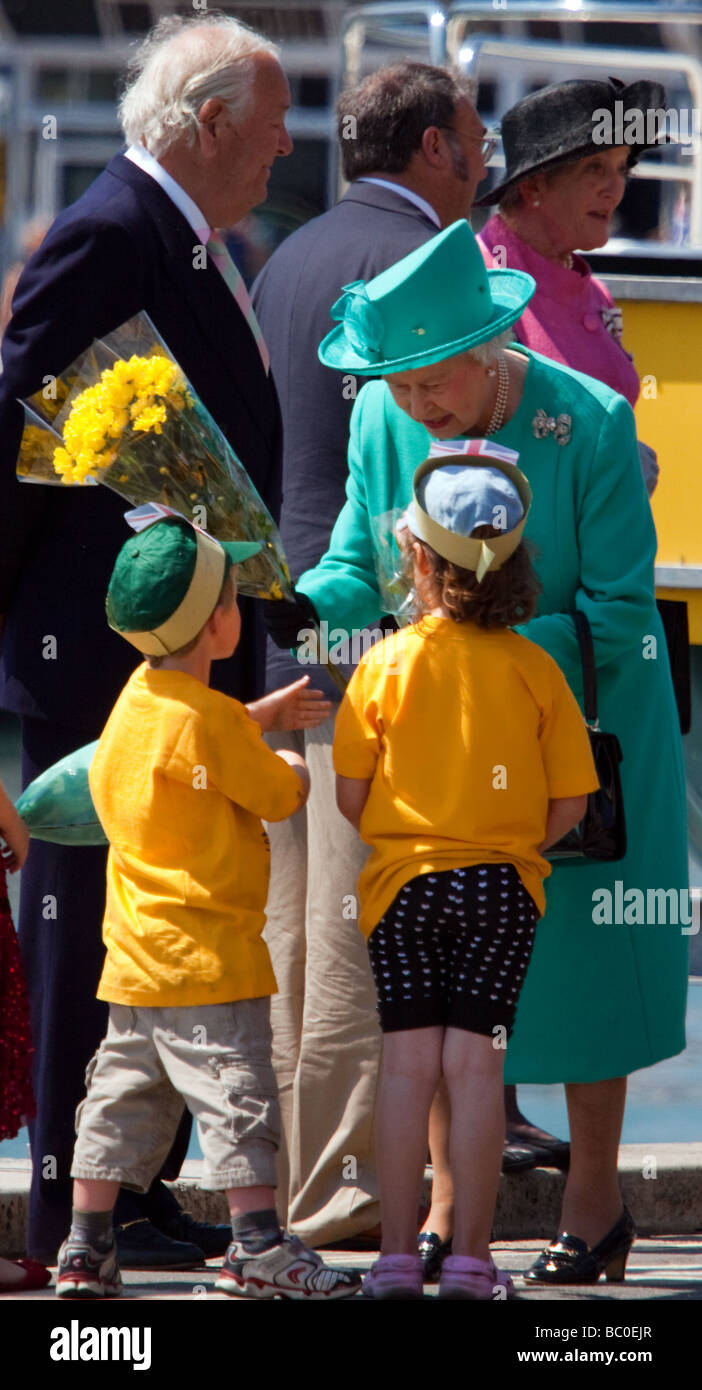The Queen Elizabeth the Second accepts a bouquet of flowers from two children in Weymouth on June 11 2009 Stock Photo