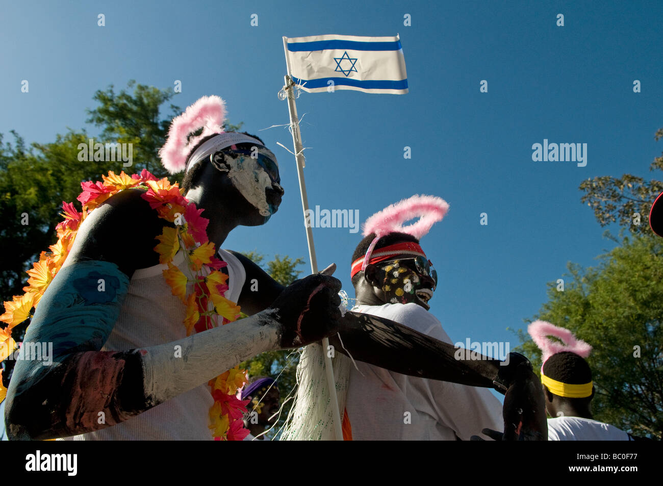 An African man holds the Israeli flag as he celebrates the UNHCR World Refugee Day in Tel Aviv Israel Stock Photo