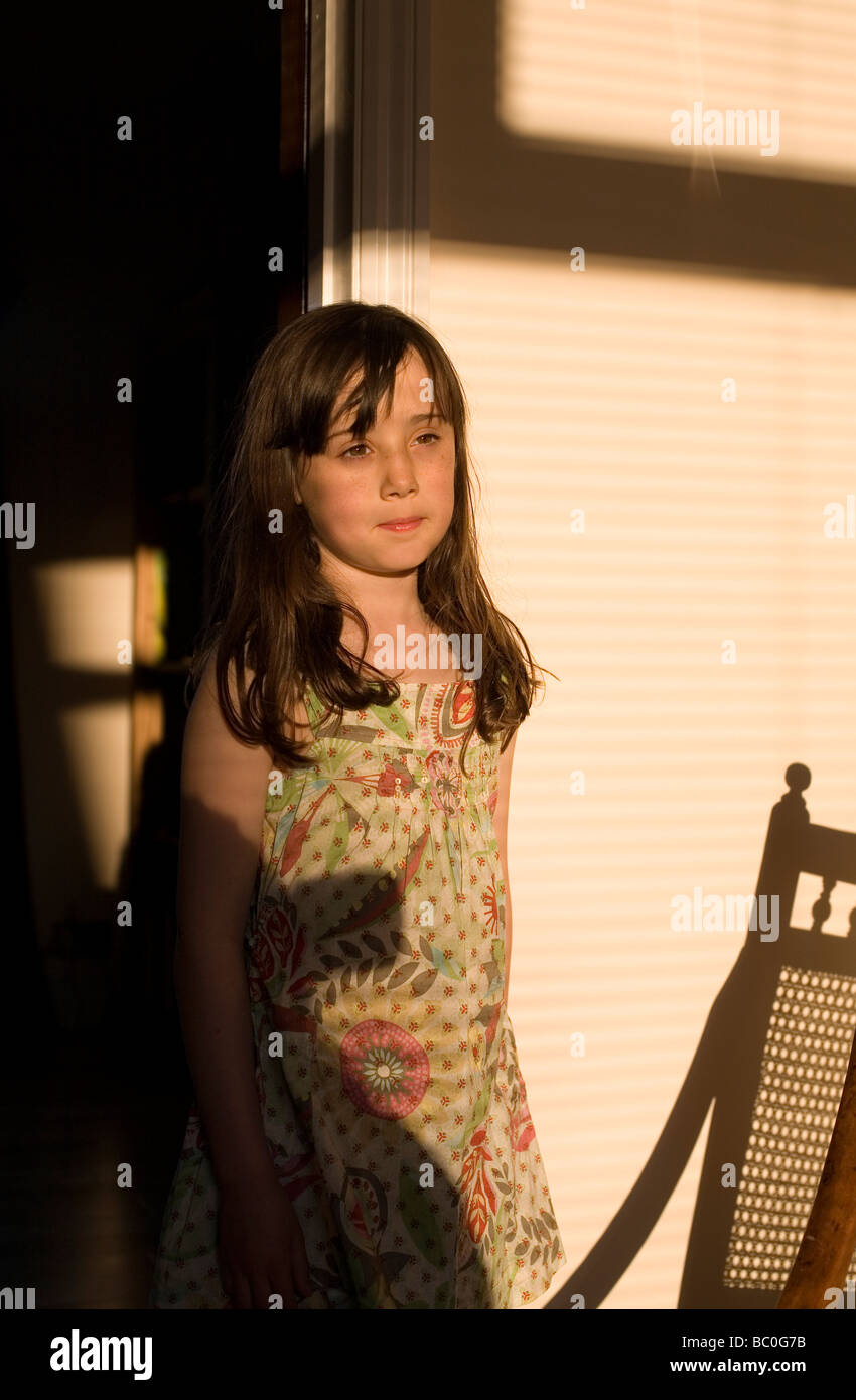 Young girl stands in doorway in evening sunlight Stock Photo - Alamy