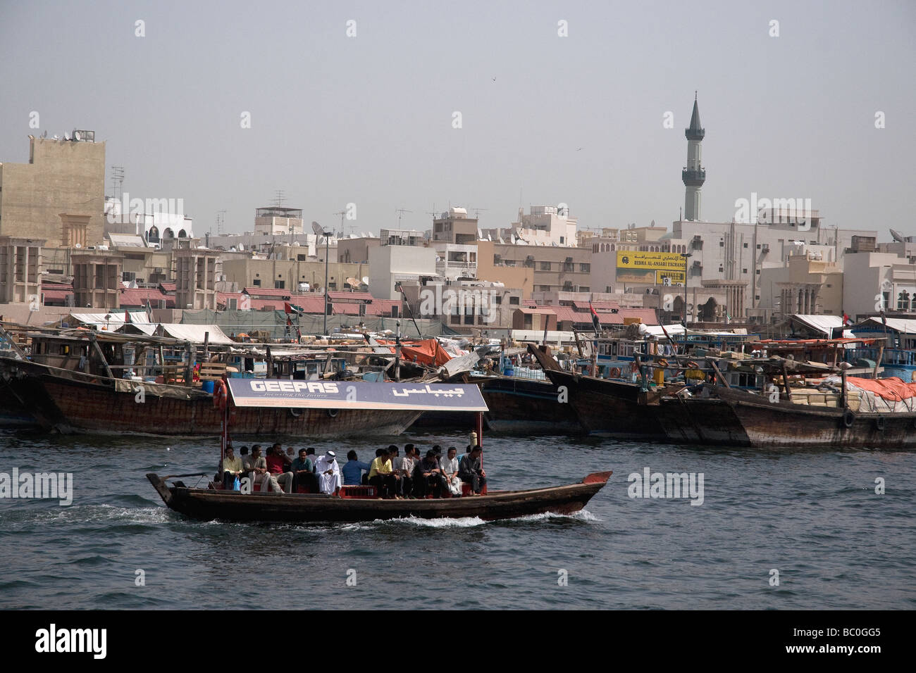 An abra, one of a busy fleet of small ferry boats crosses the Dubai creek from Bur Dubai to Deira Stock Photo