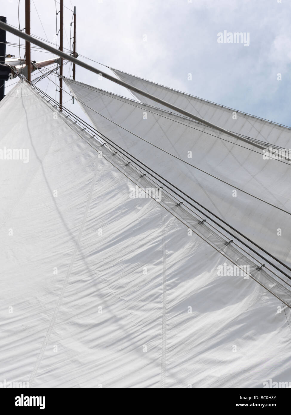 Triangular jib sails of a schooner over blue sky background Stock Photo Alamy