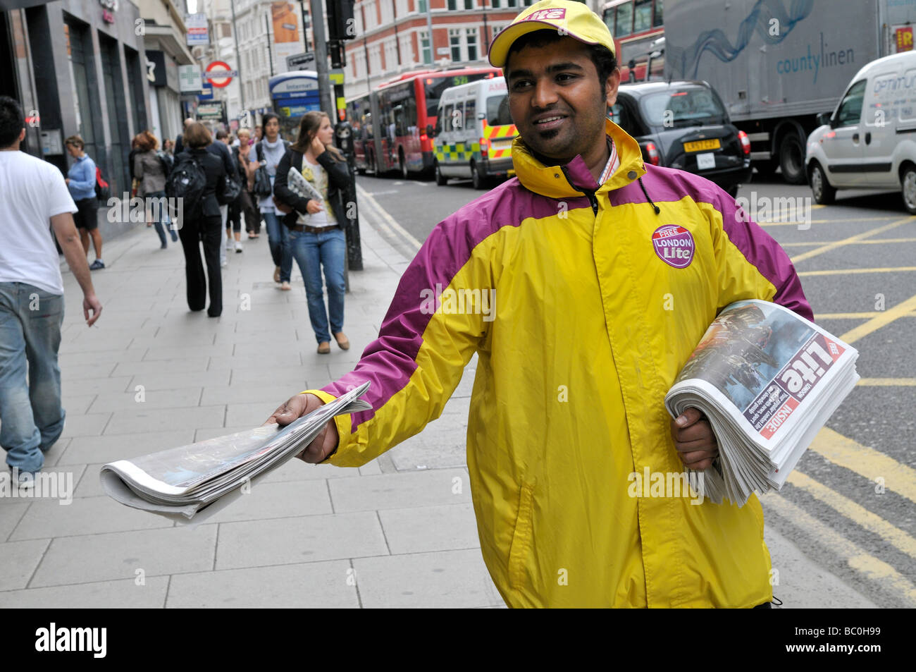 Vendor distributing free copies of London Lite newspaper Stock Photo