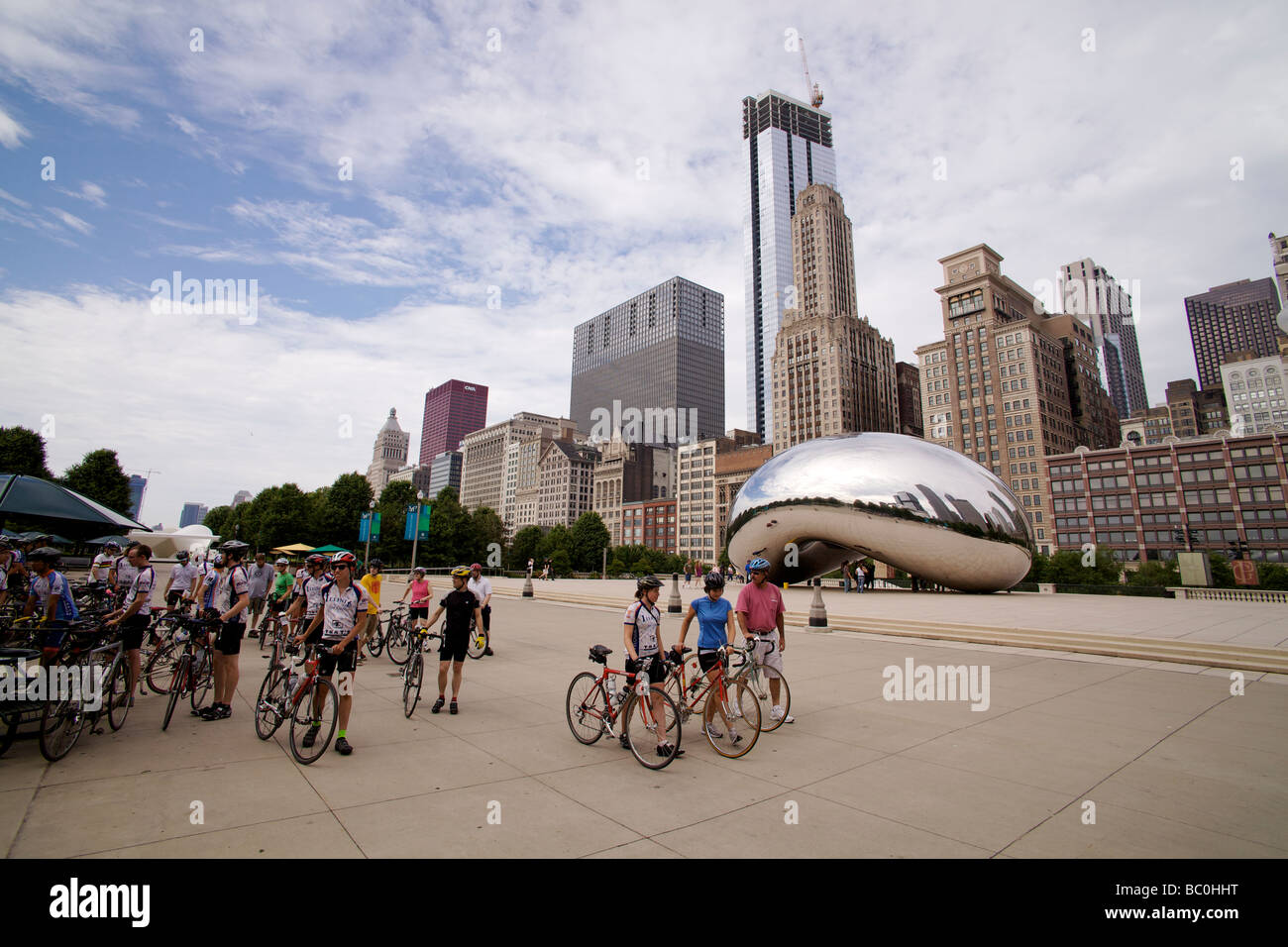 Bicyclists in Millennium Park Chicago Illinois with Anish Kapoor's Cloud Gate Sculpture also known as The Bean. Stock Photo