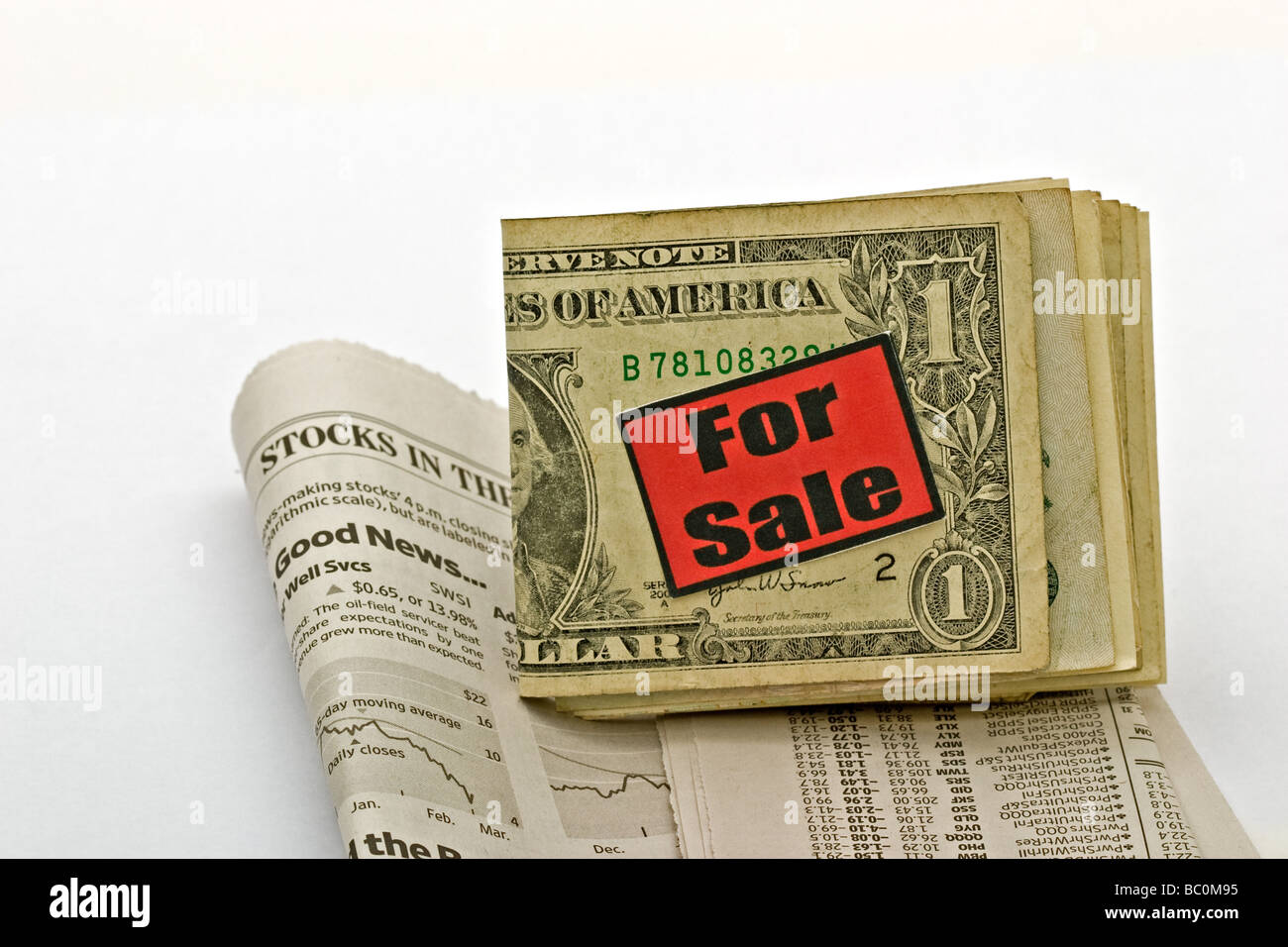 American dollar bills with a 'For Sale' sign on top of a financial newspaper Stock Photo