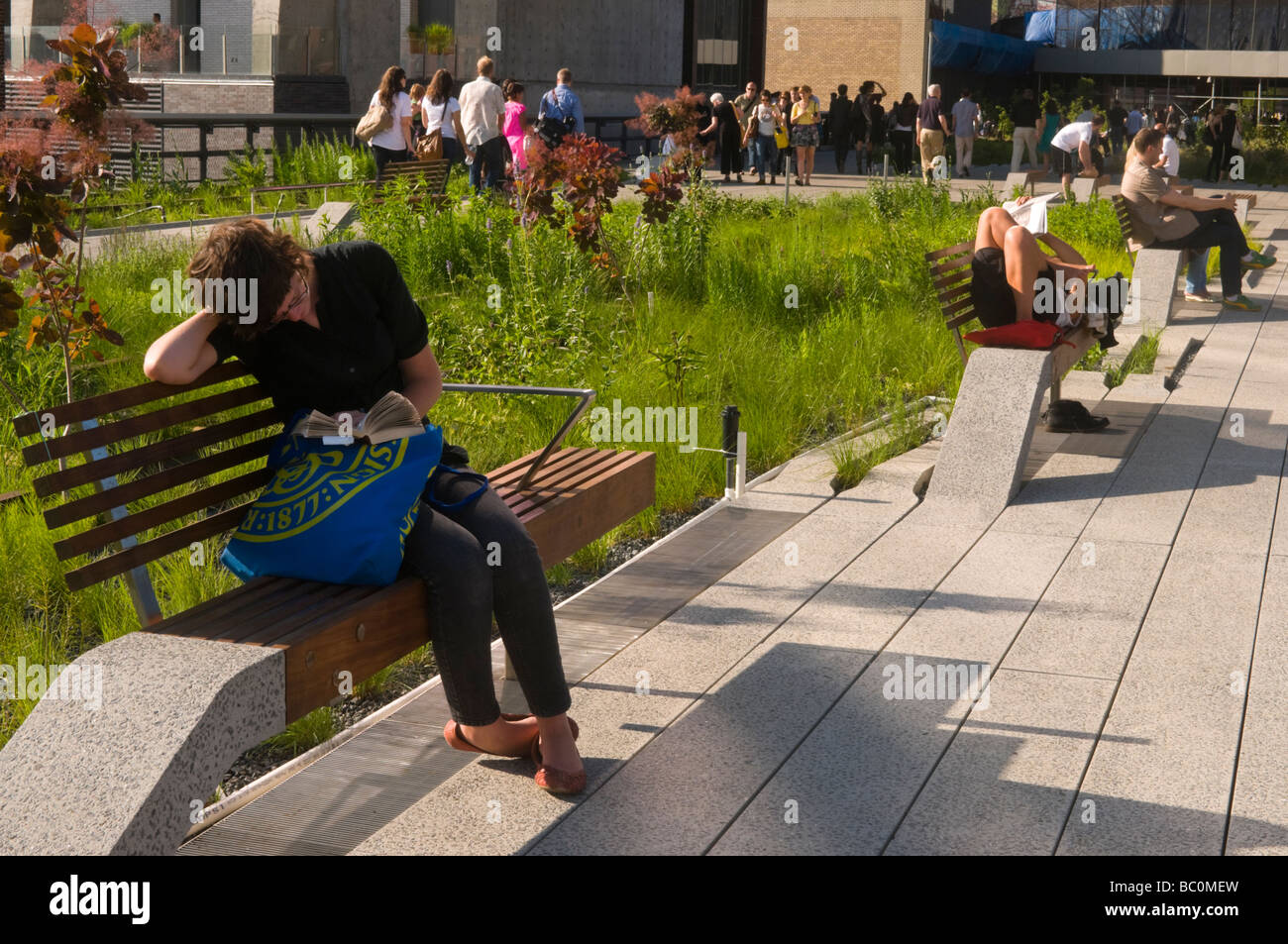Visitors read and relax on the new High Line park in the Meat Packing District of New York Stock Photo