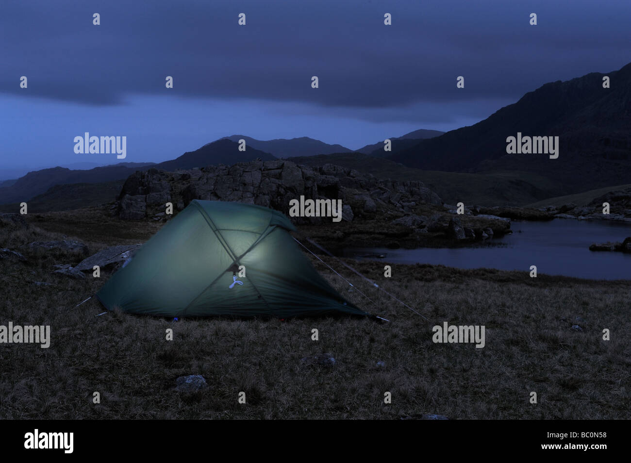 A solitary tent wild camping near a lakeland tarn in the Laked District, England, Europe Stock Photo
