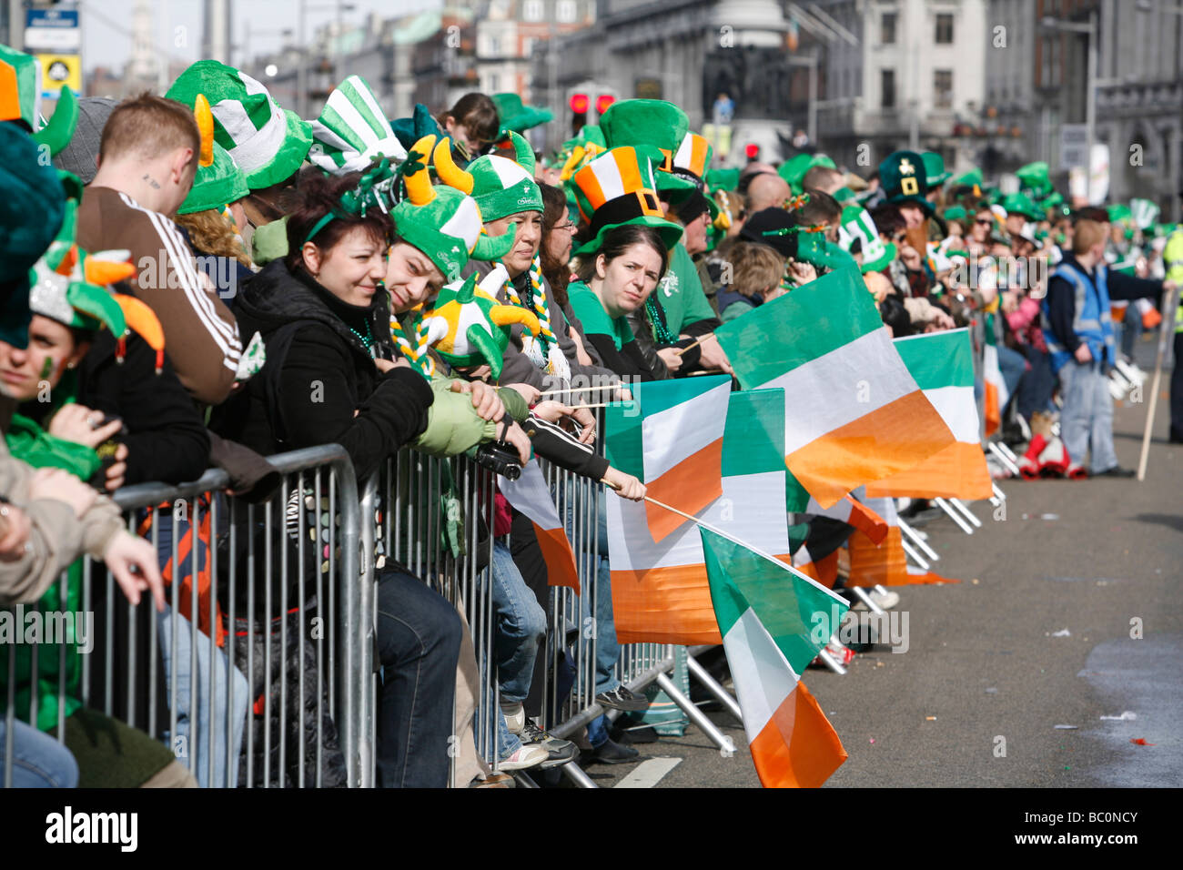 Onlooking crowd watching the 'St Patricks Day' 'Parade' Dublin Ireland with flags and hats a plenty! Stock Photo