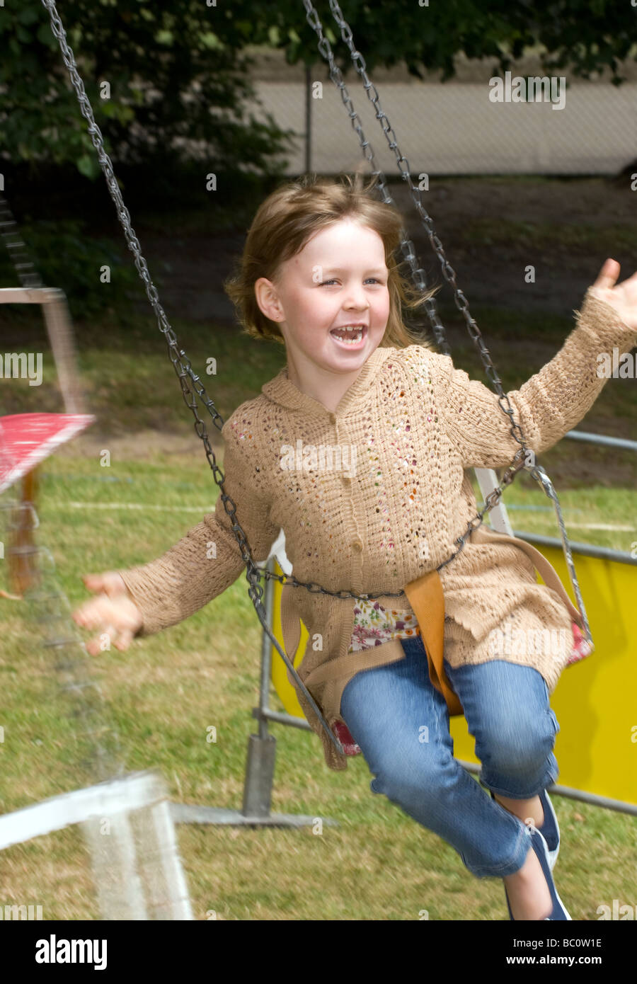 6 Year Old Girl Having Fun On A Swing At A School Summer