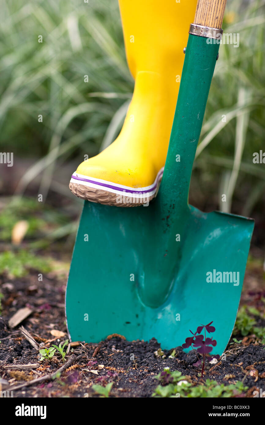 Gardener digging in soil with a spade, close up view. Stock Photo