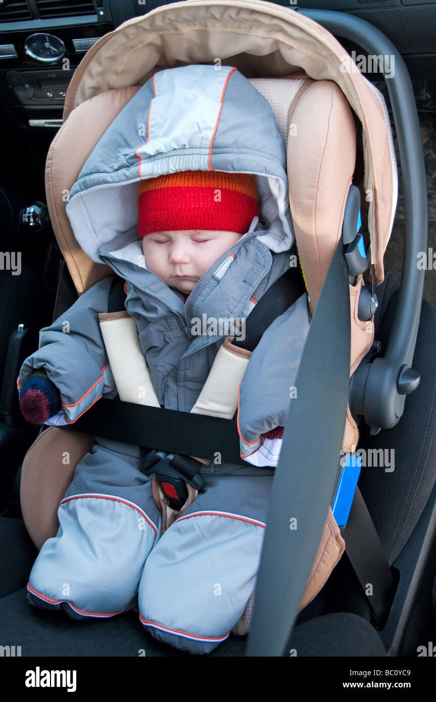 The child sleep in a safety seat on forward sitting of the car Stock Photo