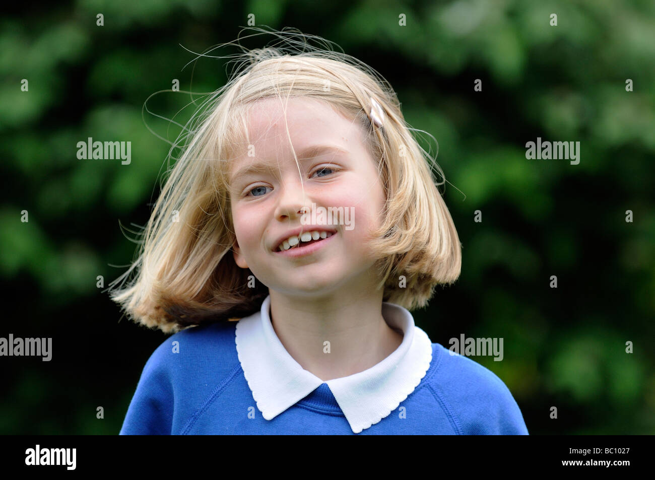 Portrait of a young girl with blonde hair and a happy smiling face ...