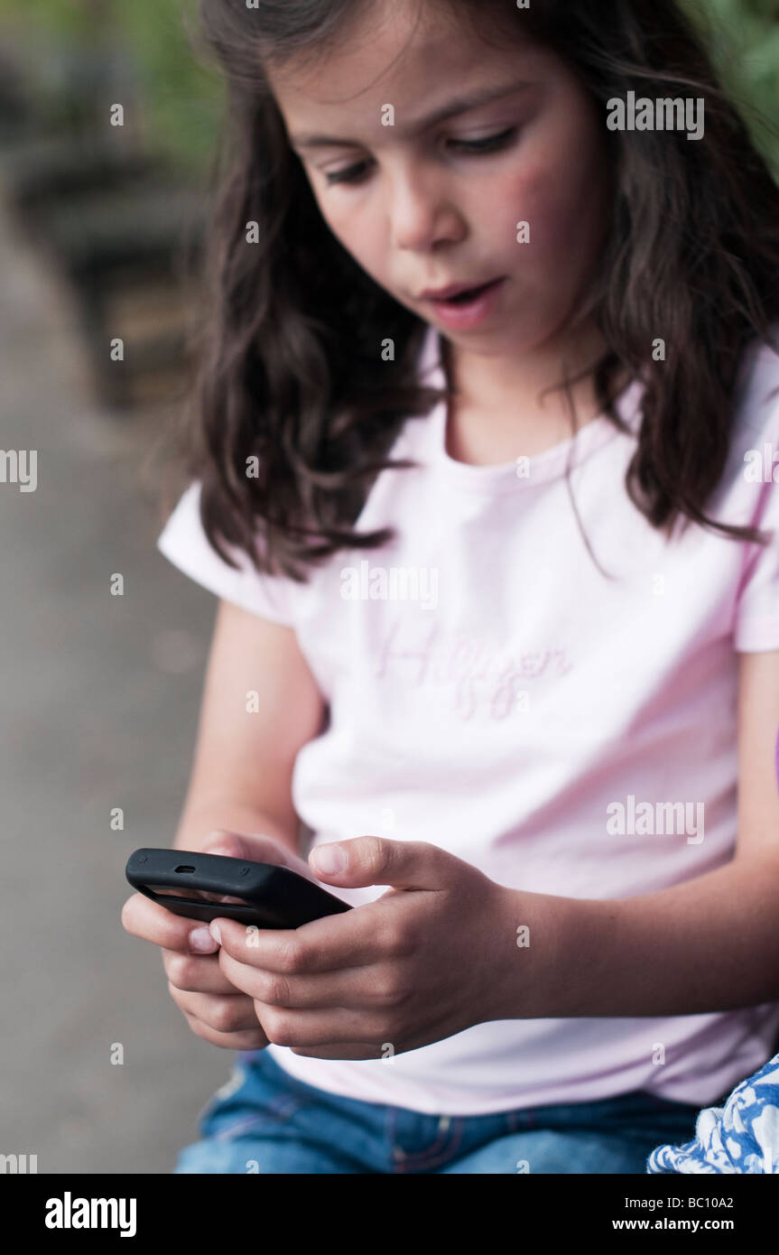 Child texting on mobile phone Stock Photo