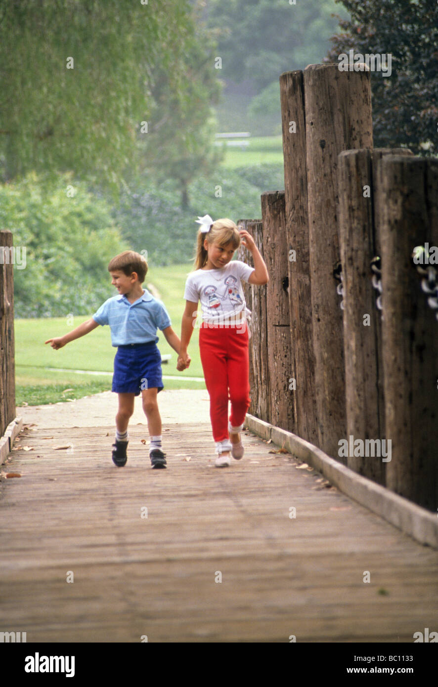 boy girl brother sister love care share walk together bridge park sibling Stock Photo