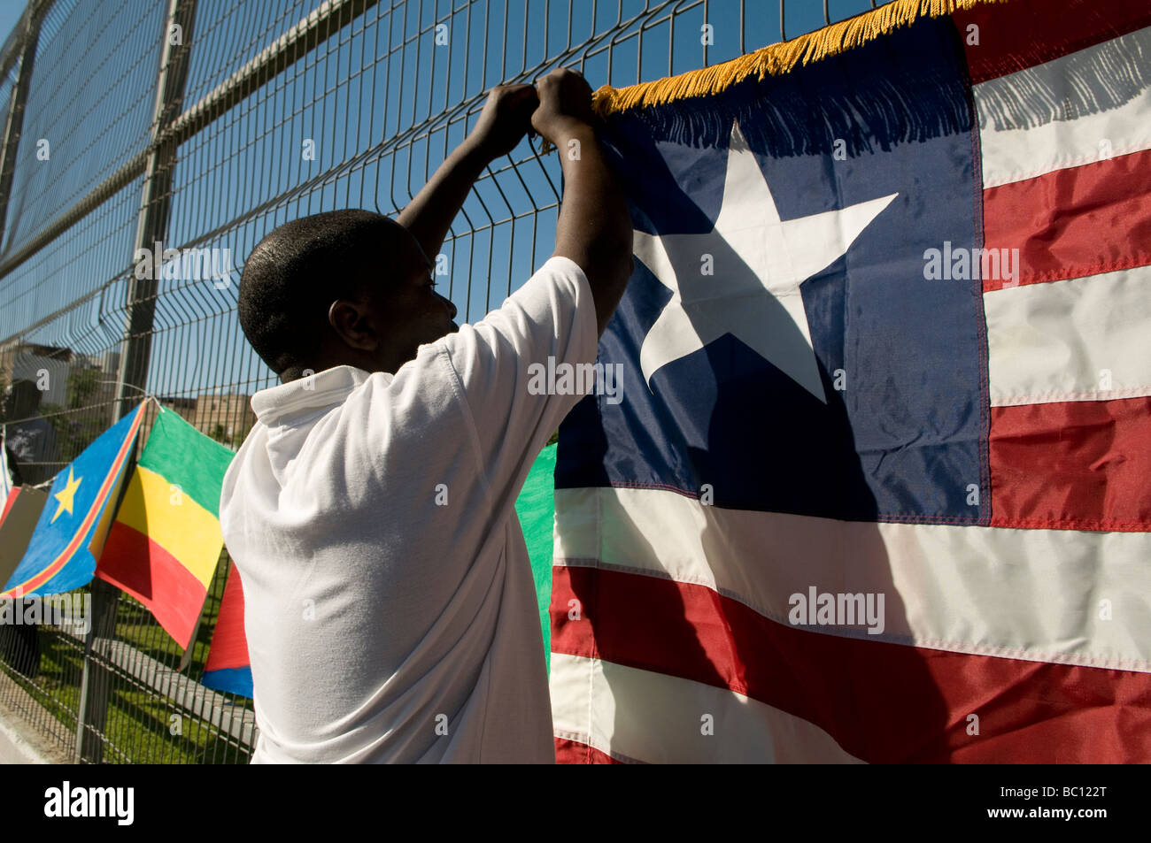 An African man hangs the flag of Liberia during UNHCR Refugee day event in Tel Aviv Israel Stock Photo