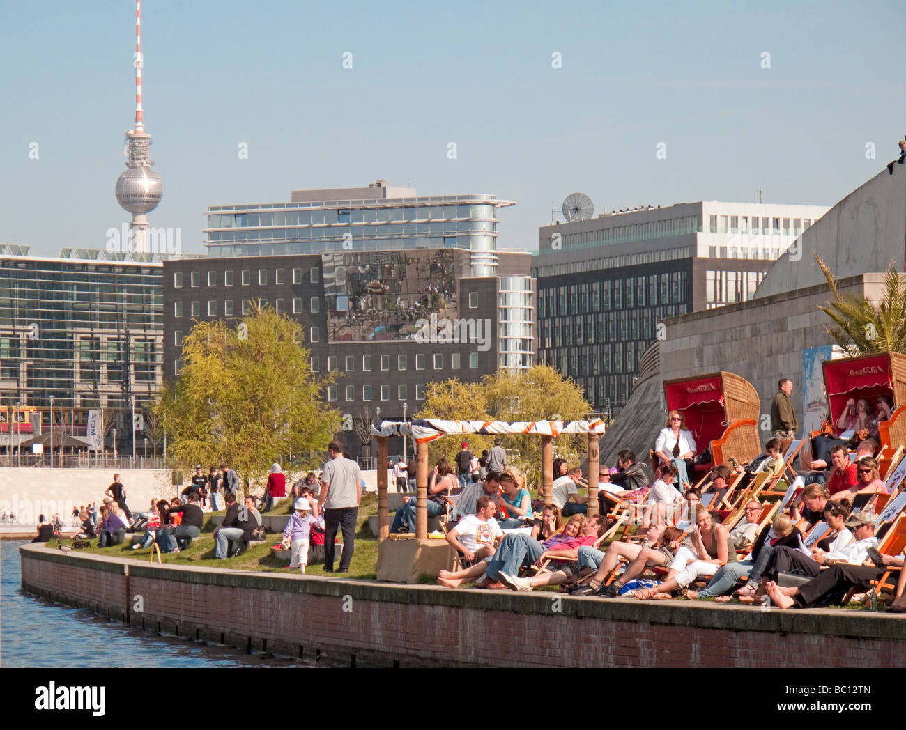 Crowds in the spring sun in Spreebogenpark Spreebogen Park along the bank of the river Spree in Berlin Germany Stock Photo