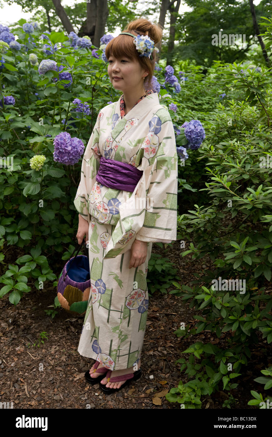 A young Japanese woman poses in a seasonal kimono in front of the