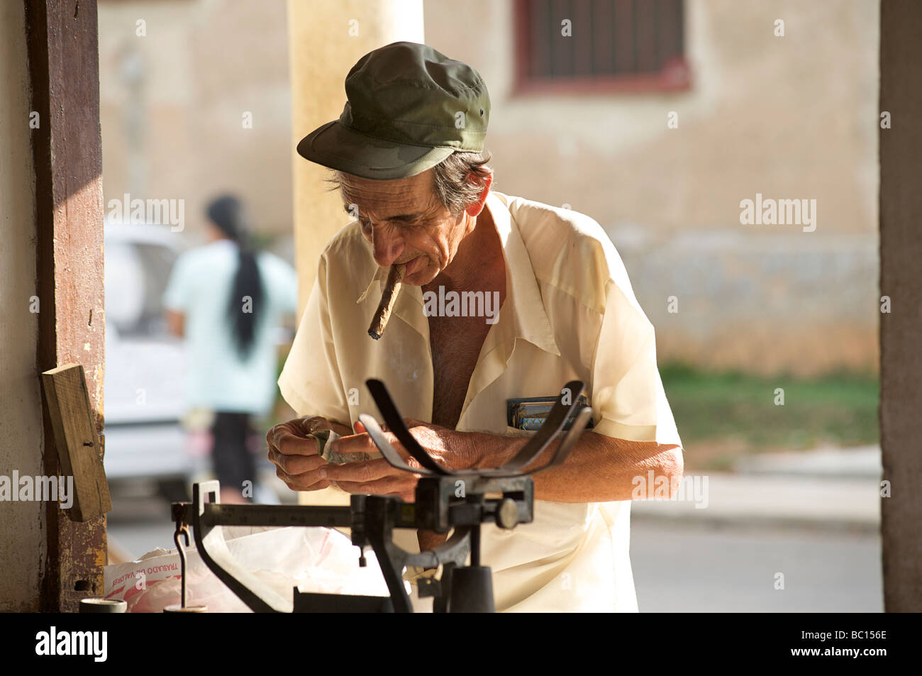 Cuban man with cigar counting money at a government owned ration shop. Viñales, Cuba Stock Photo
