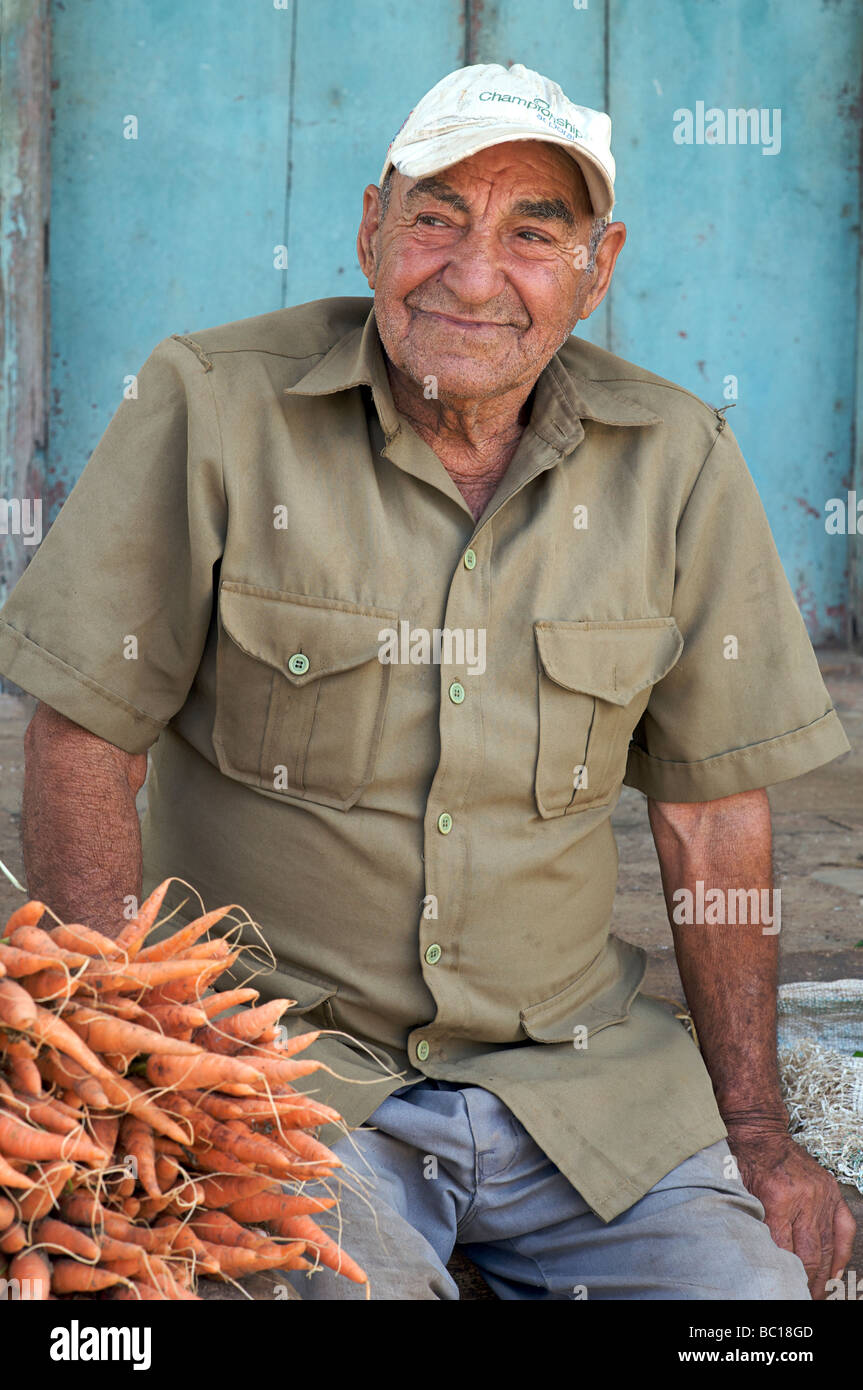Elderly Cuban man selling carrots in the street. Viñales, Cuba Stock Photo