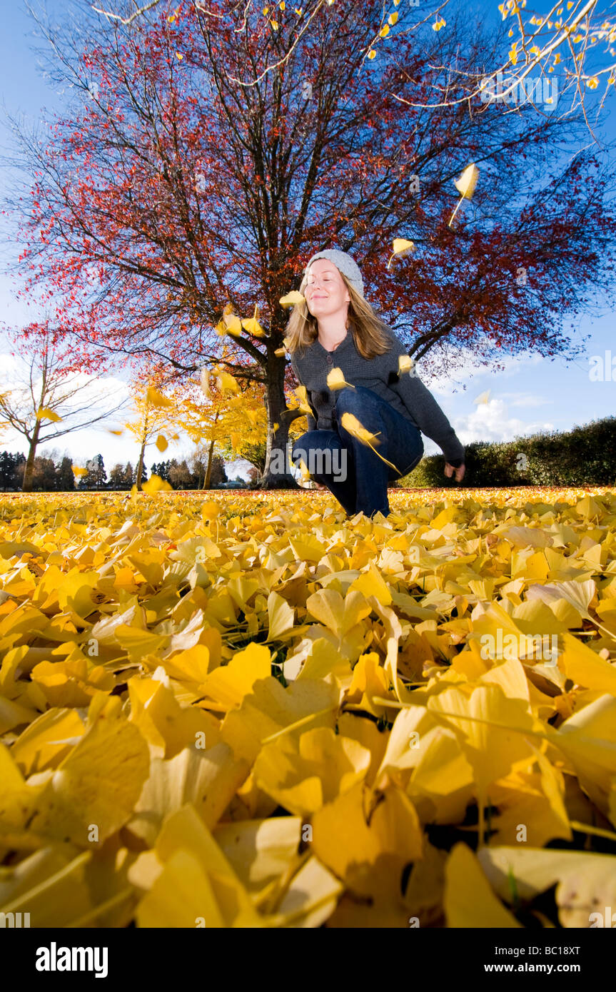 Women in park through autumn leaves Stock Photo - Alamy