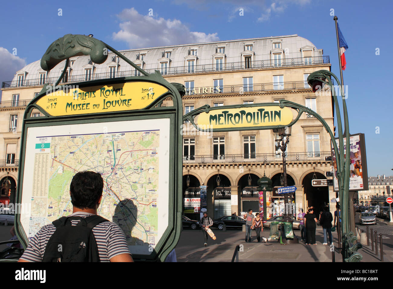 Tourist looks at Paris Métro map at art deco Louvre museum station Stock Photo