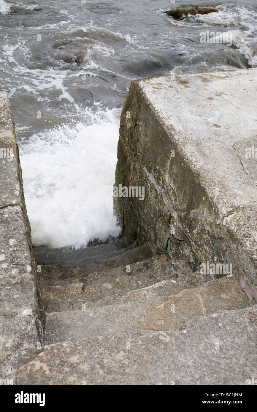 Turbulent seawater crashing into concrete steps. Stock Photo