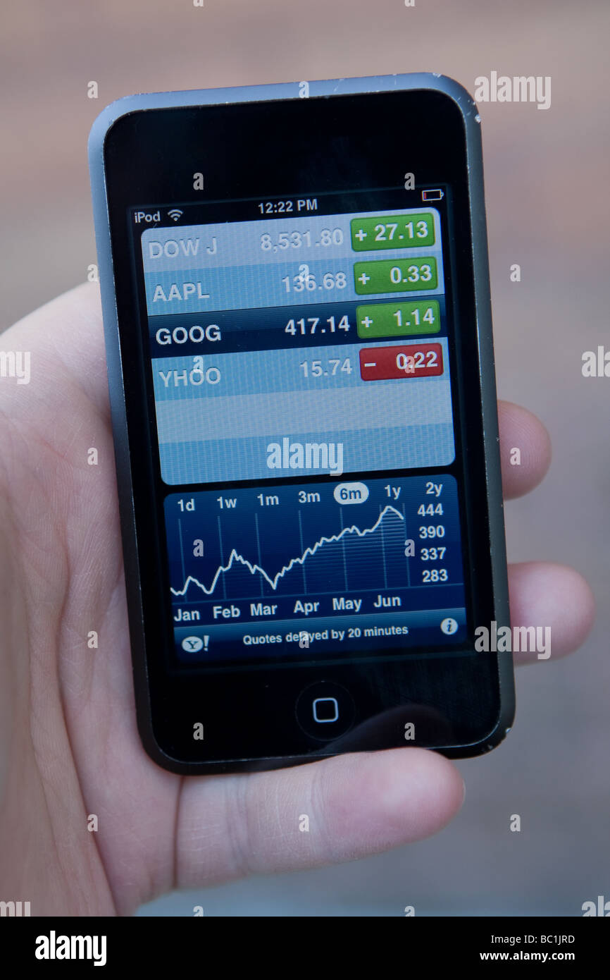 A man uses the stocks market application on an Apple Ipod Touch. Stock Photo