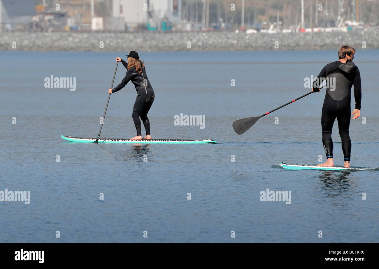 Two people gliding on paddleboards Stock Photo