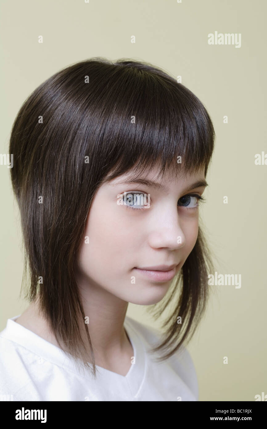 Studio portrait of girl with brown hair, smiling Stock Photo - Alamy