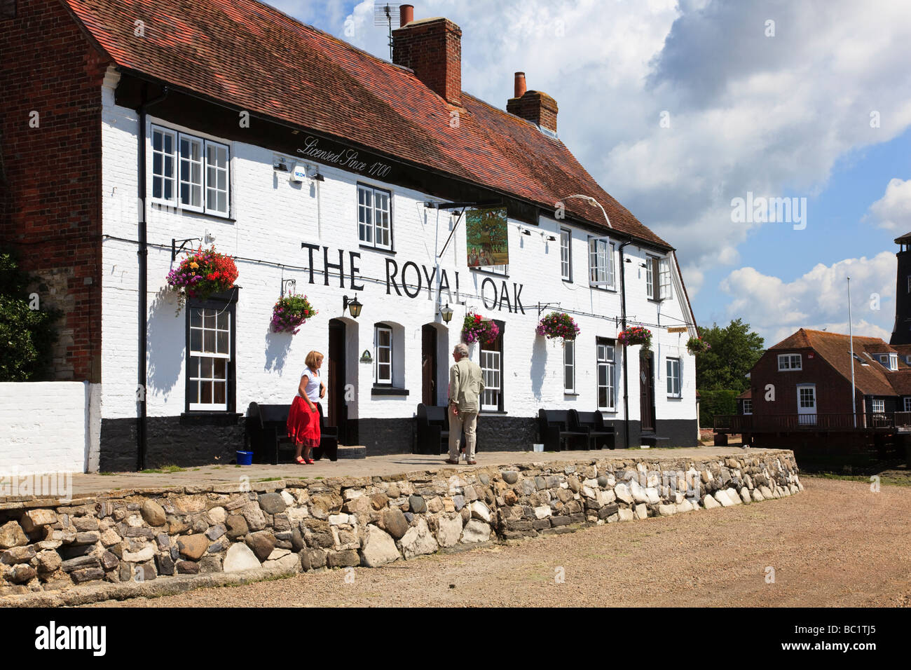 Customers outside the waterside pub, The Royal Oak, at Langstone, on the edge of Chichester Harbour Hampshire UK Stock Photo