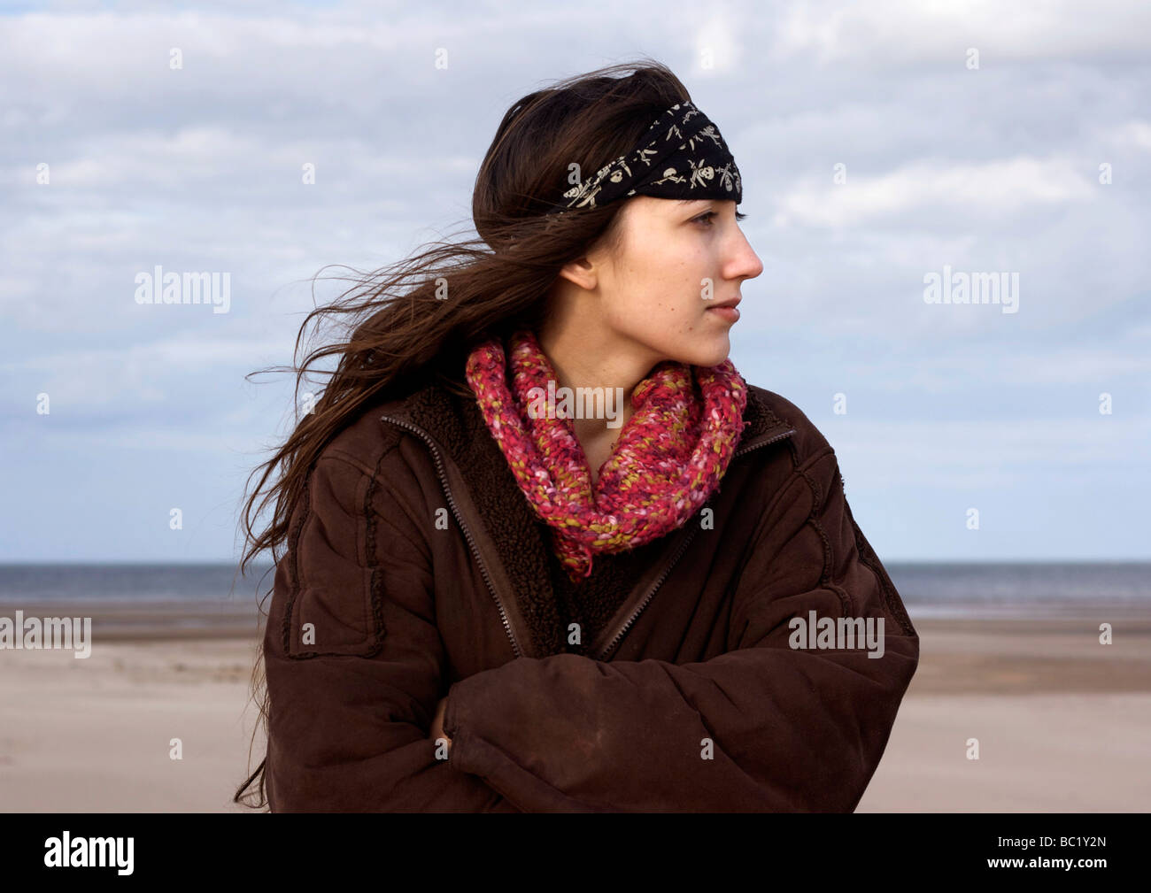 Young woman standing on the beach Stock Photo - Alamy