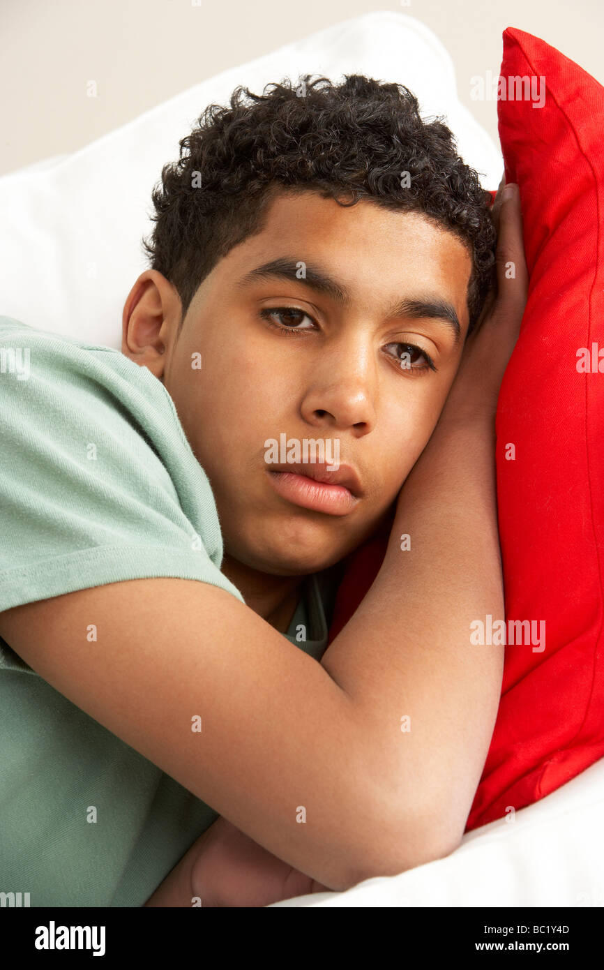 Young Boy Looking Sad On Sofa Stock Photo