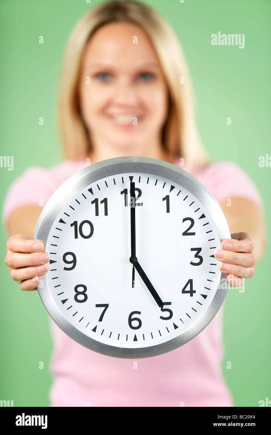 Woman Holding Clock Showing 5 O'Clock Stock Photo Alamy
