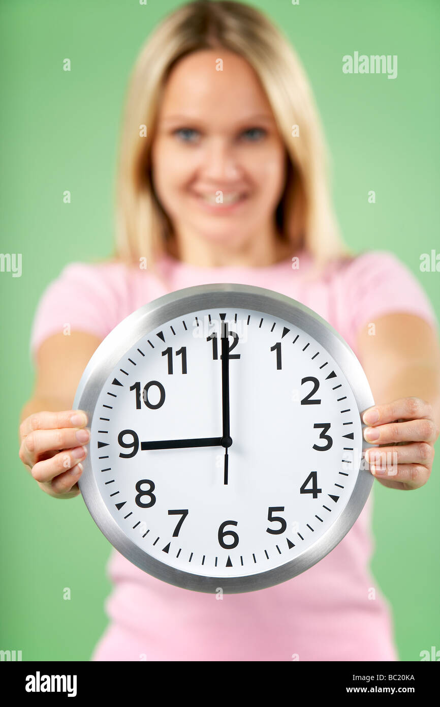 Woman Holding Clock Showing 9 O'Clock Stock Photo