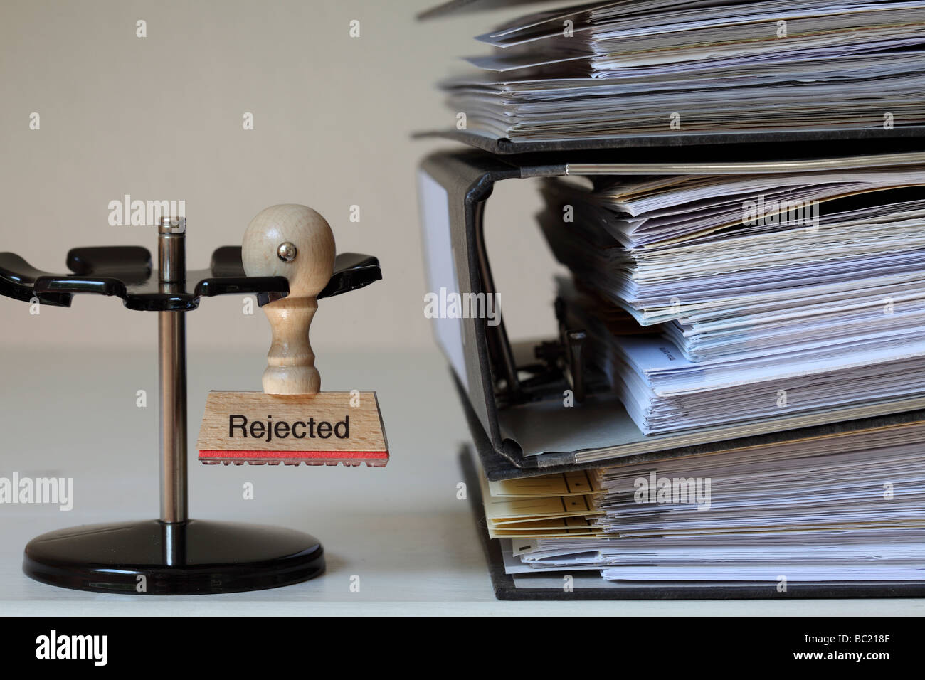 Stamp with inscription next to a pile of files Stock Photo