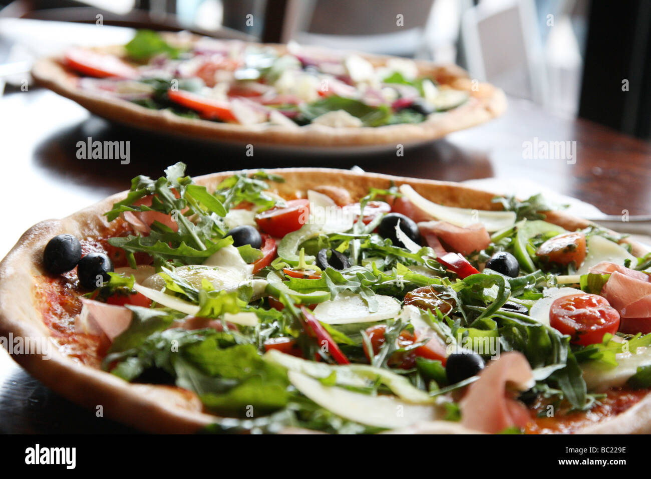 Two pizzas that look tempting and delicious ready for eating. Stone baked thin crust Stock Photo