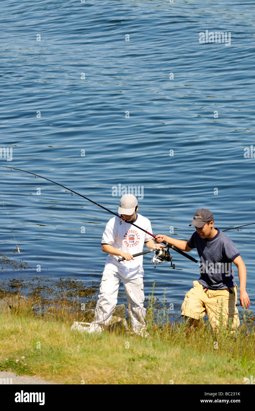 Two boys fishing at waters edge on the Cape Cod Canal in Bourne