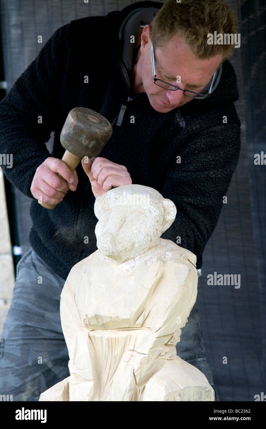 StoneMason at work carving stone monkey at a craft fair in Derbyshire East Midlands England