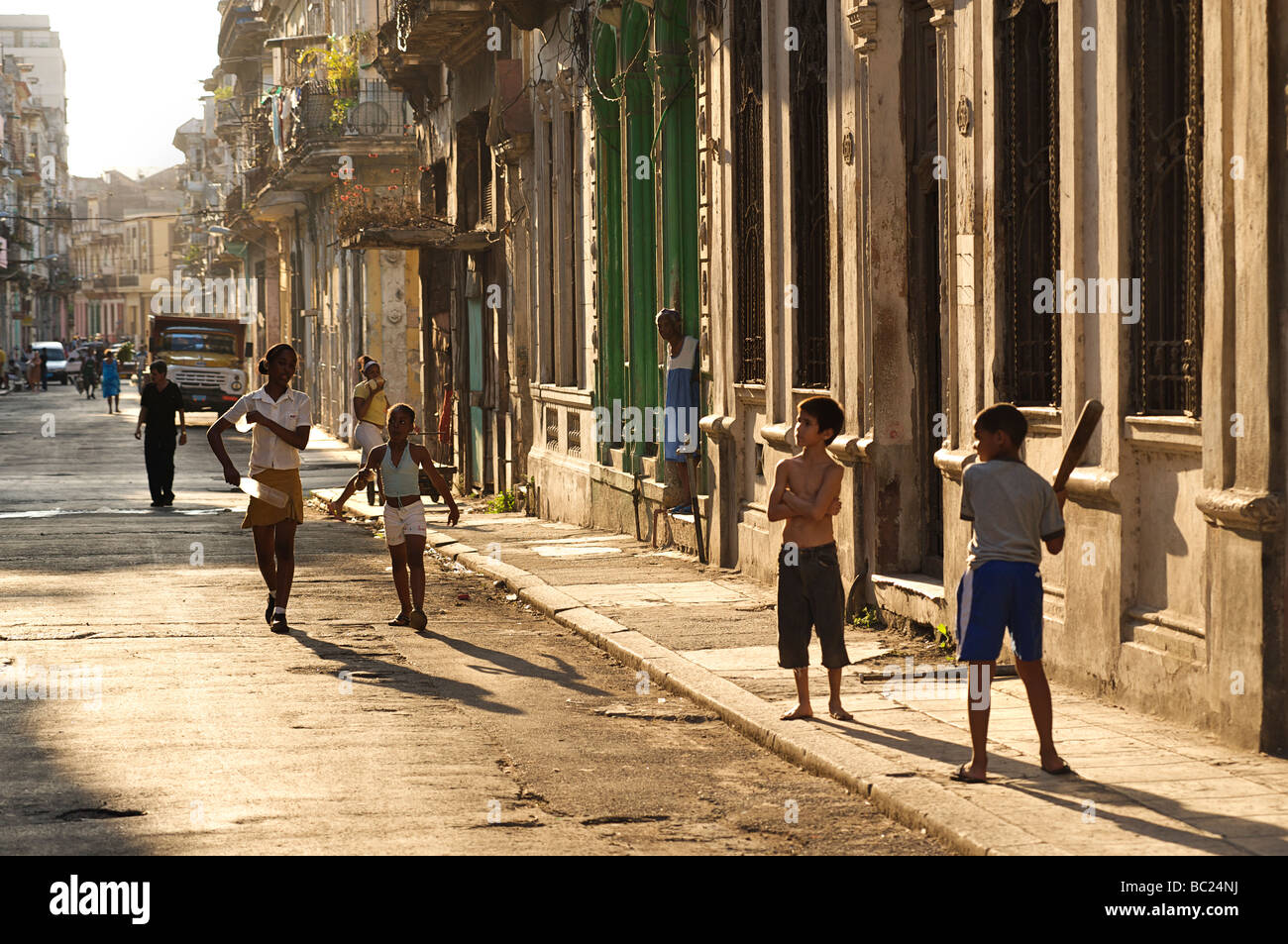 Cuban street scene. Late afternoon in Habana Centro. Children playing baseball in the street. Havana, Cuba Stock Photo