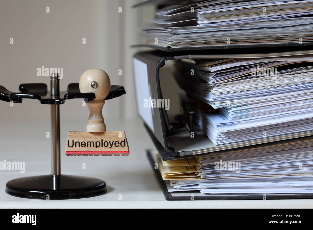 Stamp with inscription Unemployed next to a pile of files Stock Photo