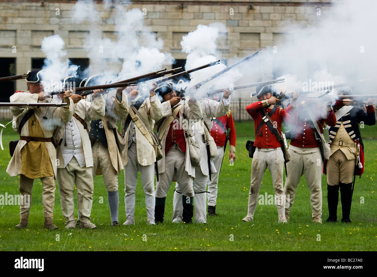 Men dressed in Revolutionary War period soldier uniforms firing muskets at Fort Adams in Newport, Rhode Island. Stock Photo