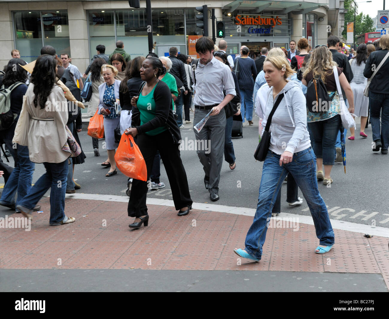 Pedestrians crossing junction by Sainsburys on High Holborn in London ...