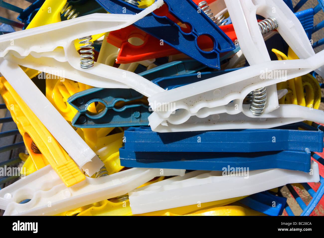 Cheap plastic clothes pegs in plastic basket Stock Photo