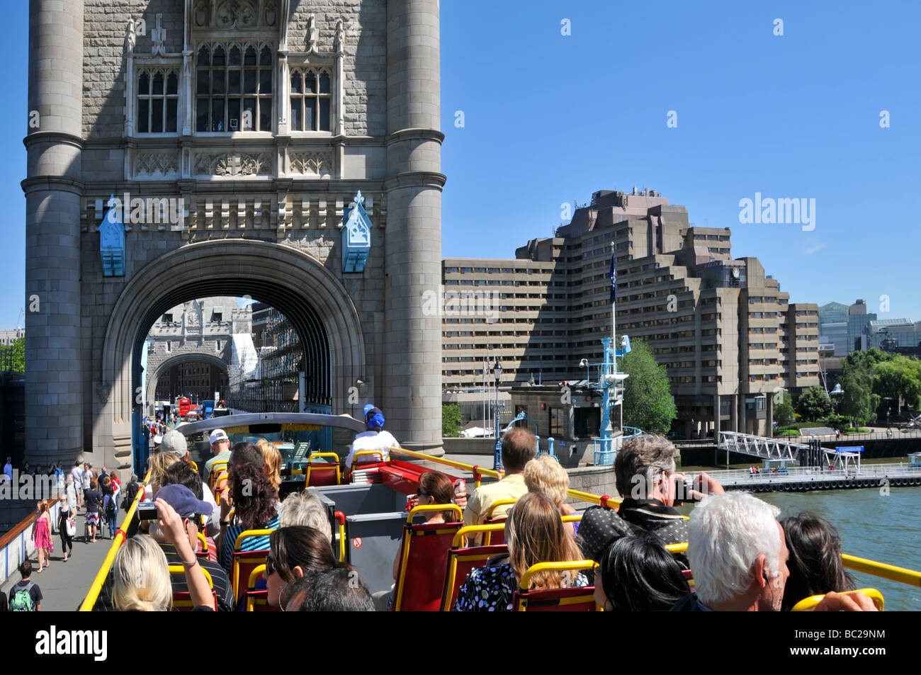 London top deck of open top tour bus passengers taking pictures of