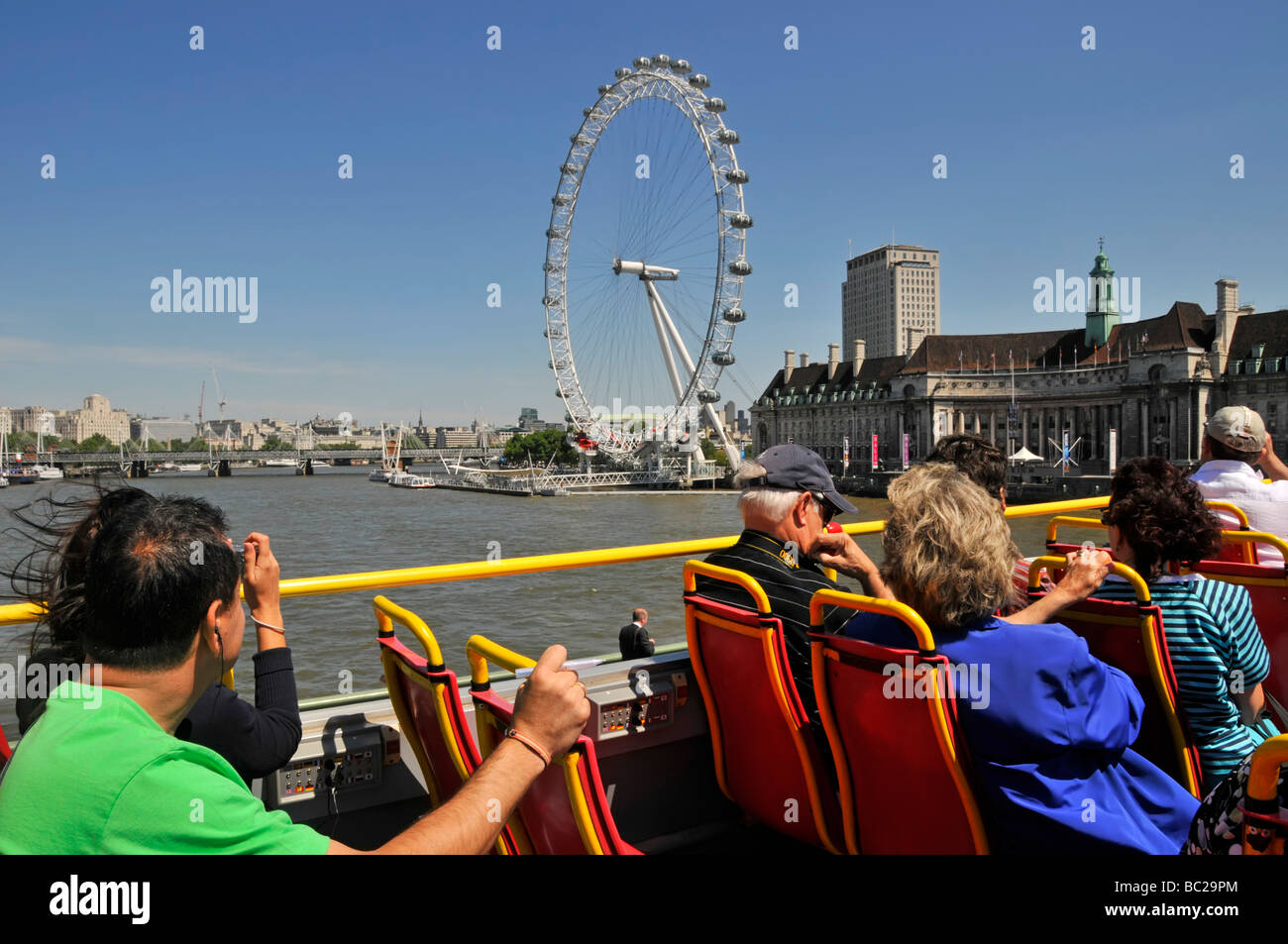 London top deck of open top tour bus passengers taking pictures of
