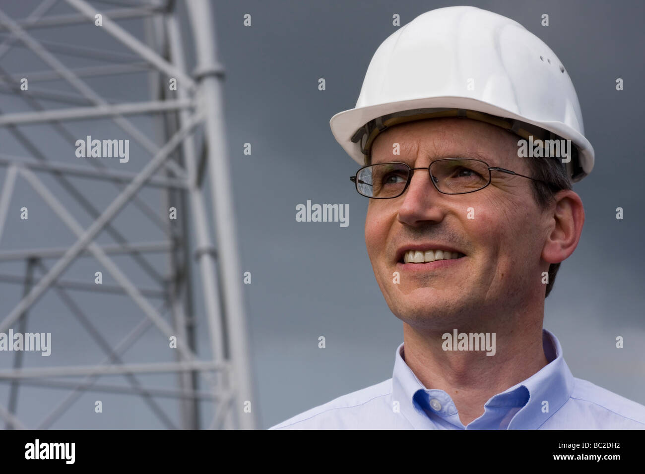 Smiling engineer with helmet on construction site Stock Photo