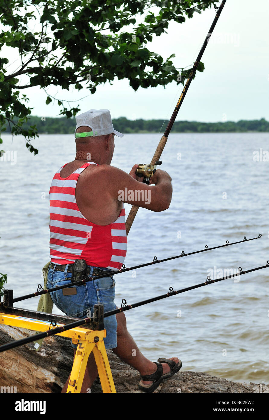 An old man catches a small fish at lake Hefner in Oklahoma, USA. Stock Photo
