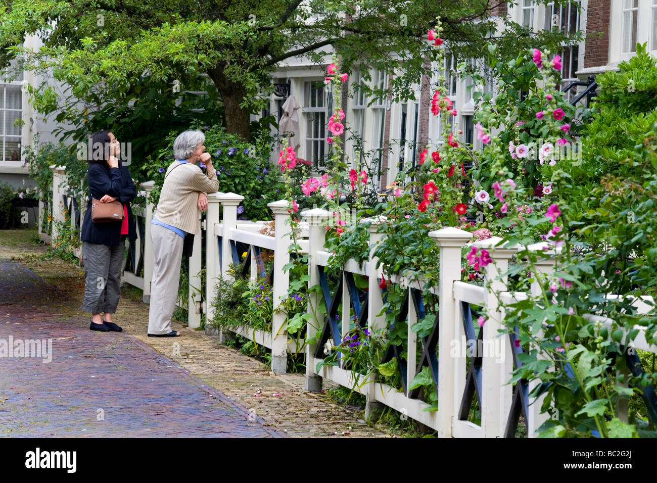 two ladies in a house gate Begijnhof inner court, Amsterdam, Netherland Stock Photo
