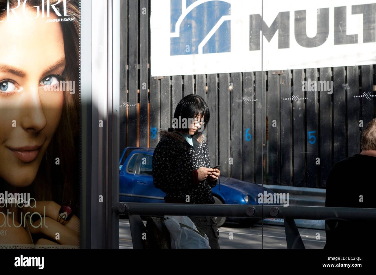Woman texting at a tram stop Bourke Street Melbourne Victoria Australia Stock Photo