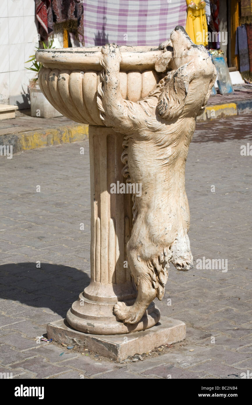 Water fountain with statue of thirsty dog trying to reach water, Red Sea coastal town, Egypt, North Africa Stock Photo